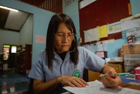 Darunee Khongkarat, a microscopy technician fills out a surveillance form on a malaria patient. © WHO 2023