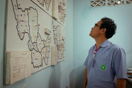 At the Vector Borne Disease Unit (VBDU), the Chief Public Health Officer analyzes a large map of Mae Sariang district, using pins to strategically track malaria cases. © WHO 2023