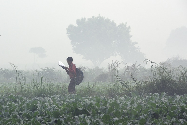 Air Pollution - Boy reading a book in urban area facing ambient outdoor pollution. Boy reading a book in urban area facing ambient outdoor pollution.