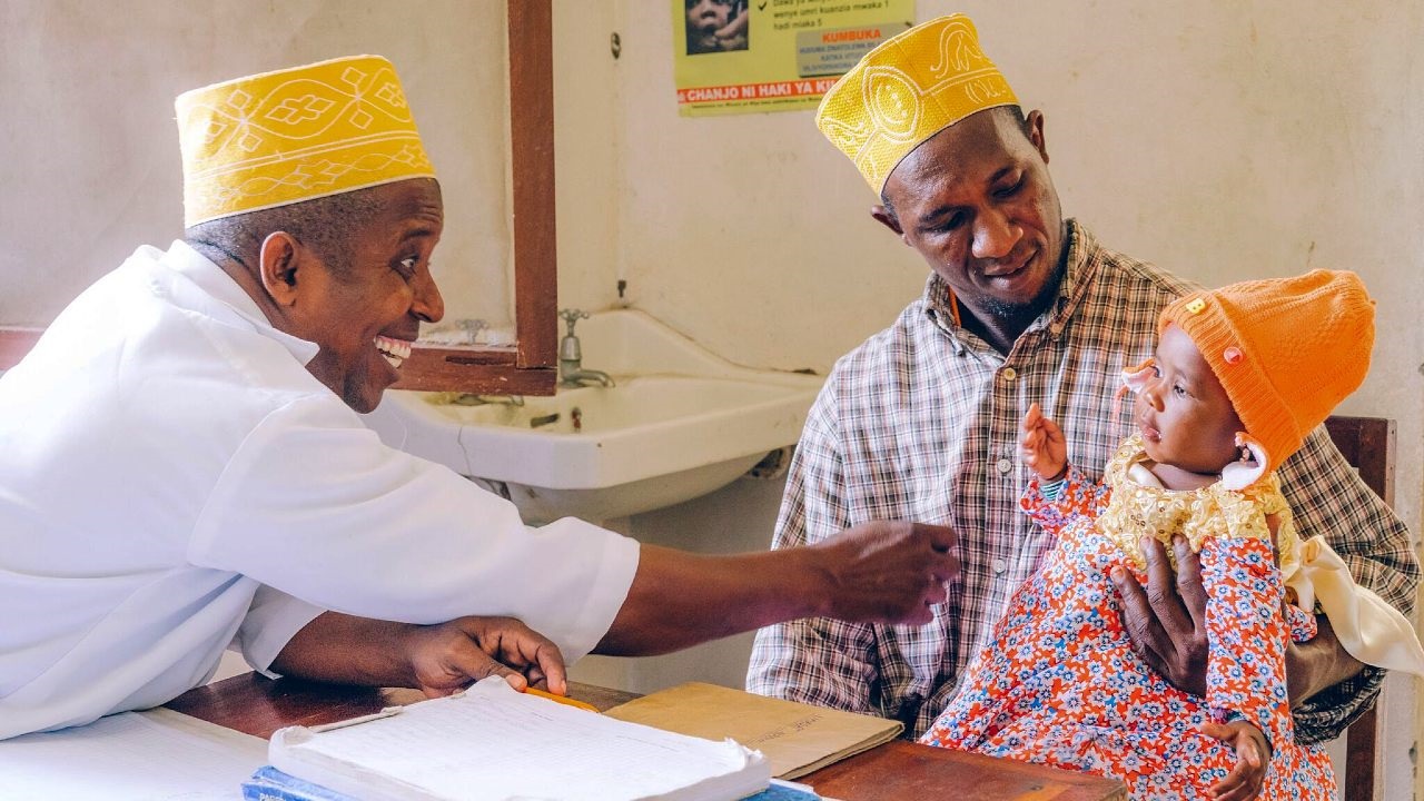 Zanzibar- Said Ali2 Health worker smiling at baby during a health check.
