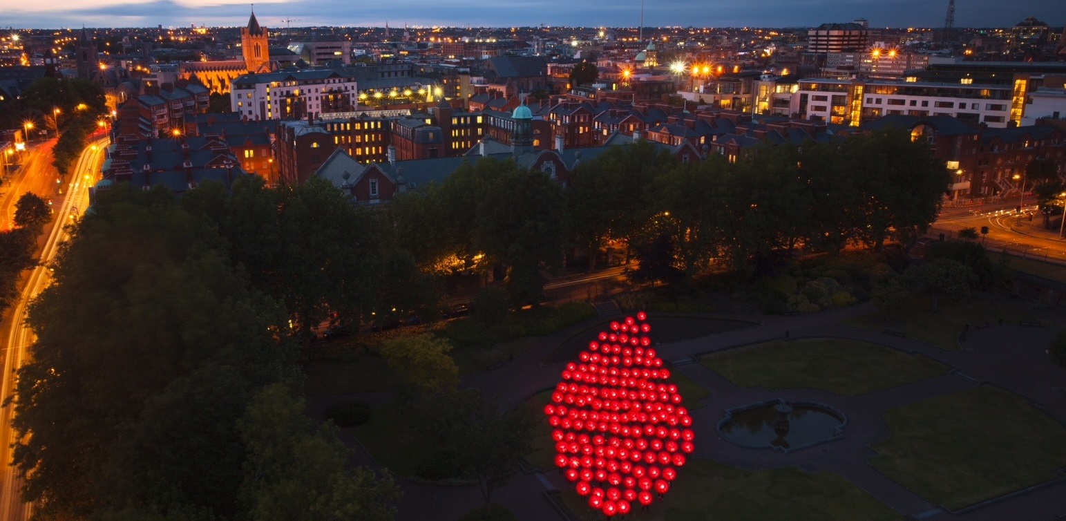 Une goutte de sang constituée de points lumineux dans une ville.