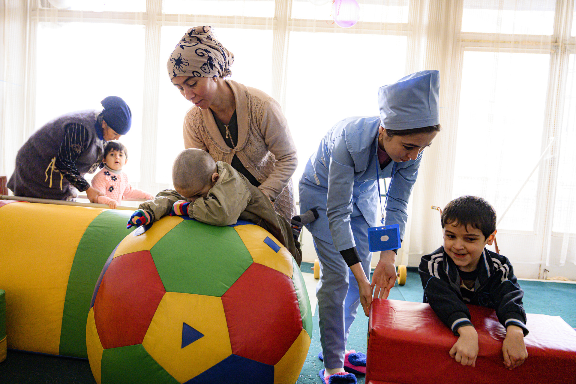 Three children undergoing rehabilitation by three female health workers