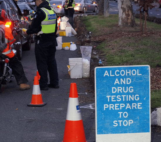 A traffic inspection site with a sign that says alcohol and drug testing prepare to stop