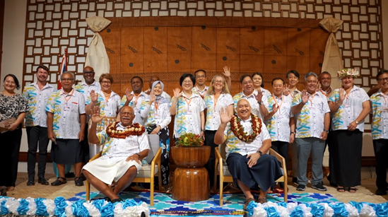 A group of people waving and smiling at the camera