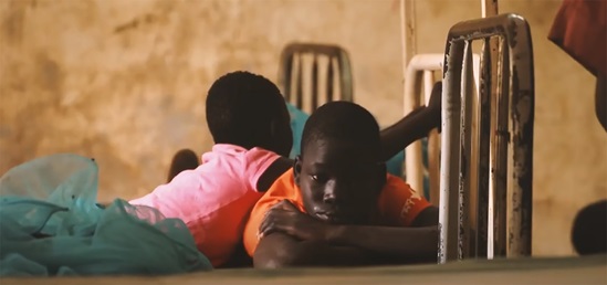 A screenshot of two young boys lying on their fronts.