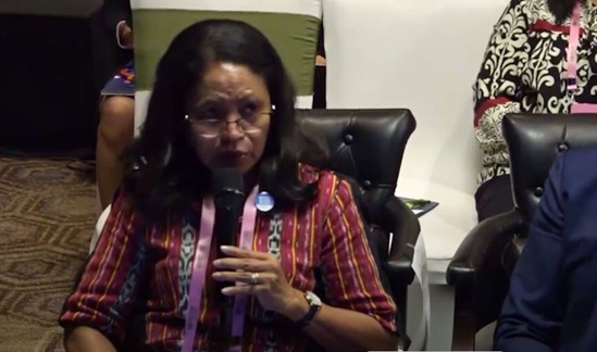 Video snapshot of Tomasia de Sousa speaking from her seat at a meeting.