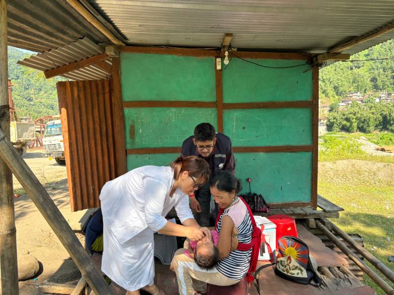 A mother holds her child during a vaccination session in Pachan Morang Colony, East Kameng, Arunachal Pradesh, under WHO-supported immunization outreach.