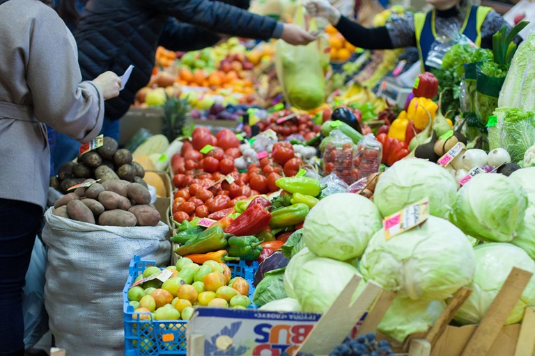 People are selecting vegetables at an open-air market, Moscow, Russia.