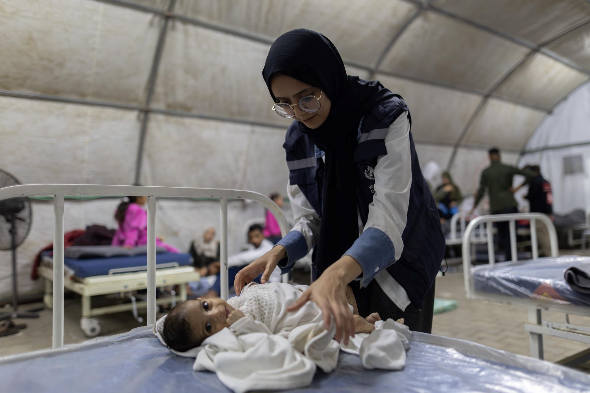 Woman in WHO jakcet with a smiling baby