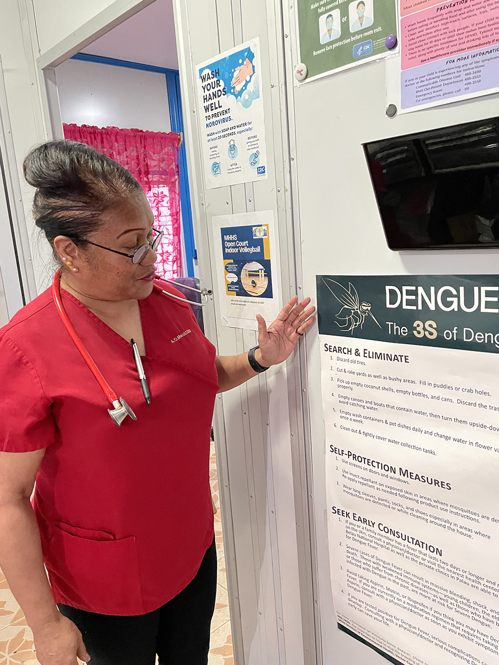 A public health doctor points to a dengue poster in a health facility in Palau