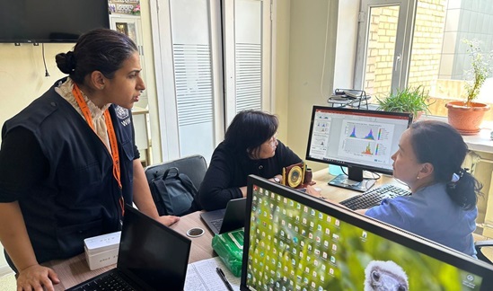 Clinical infectious diseases specialists looking at a computer screen with  disease data