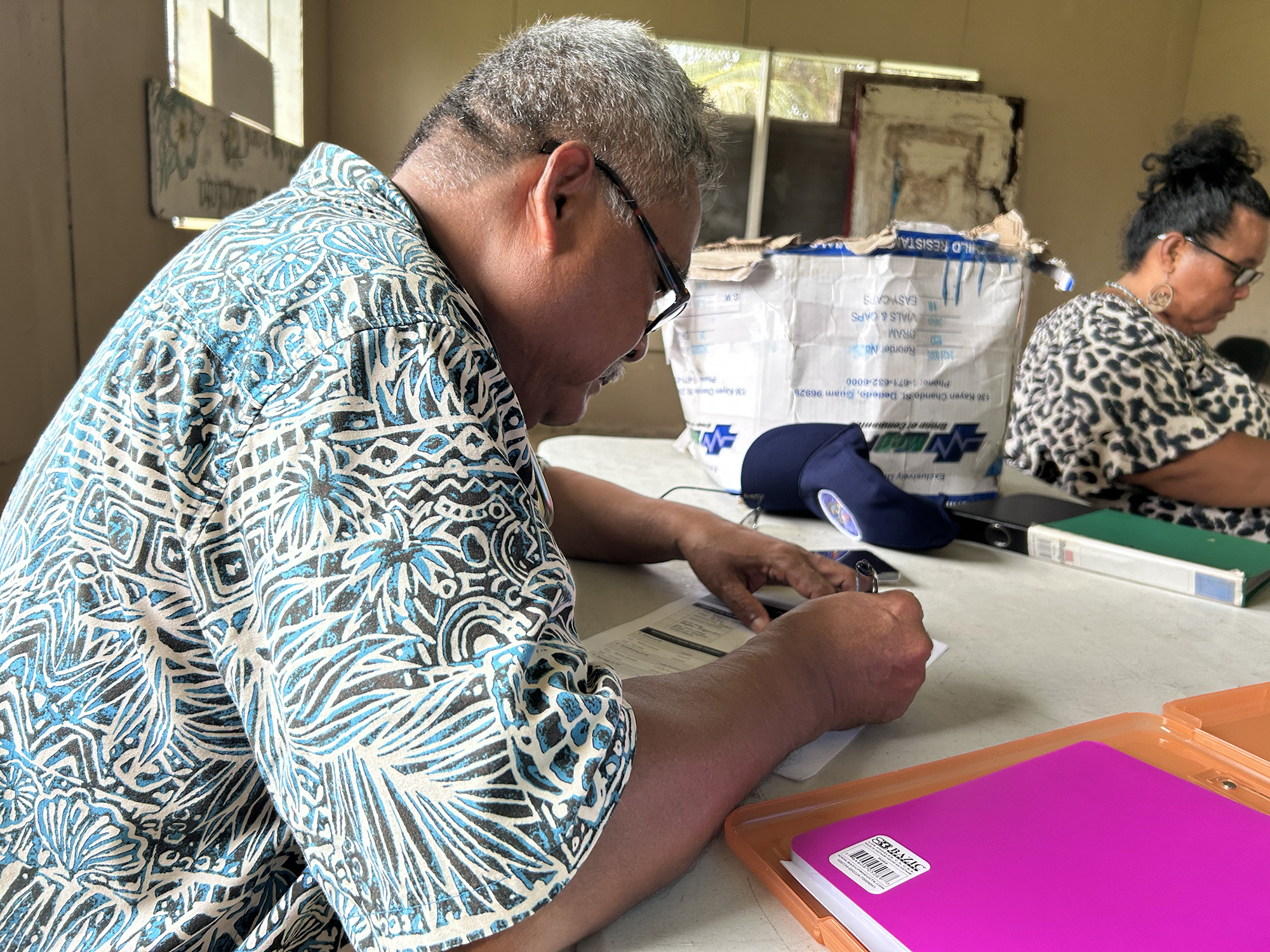 A man notes down data on a form during a health risk assessment