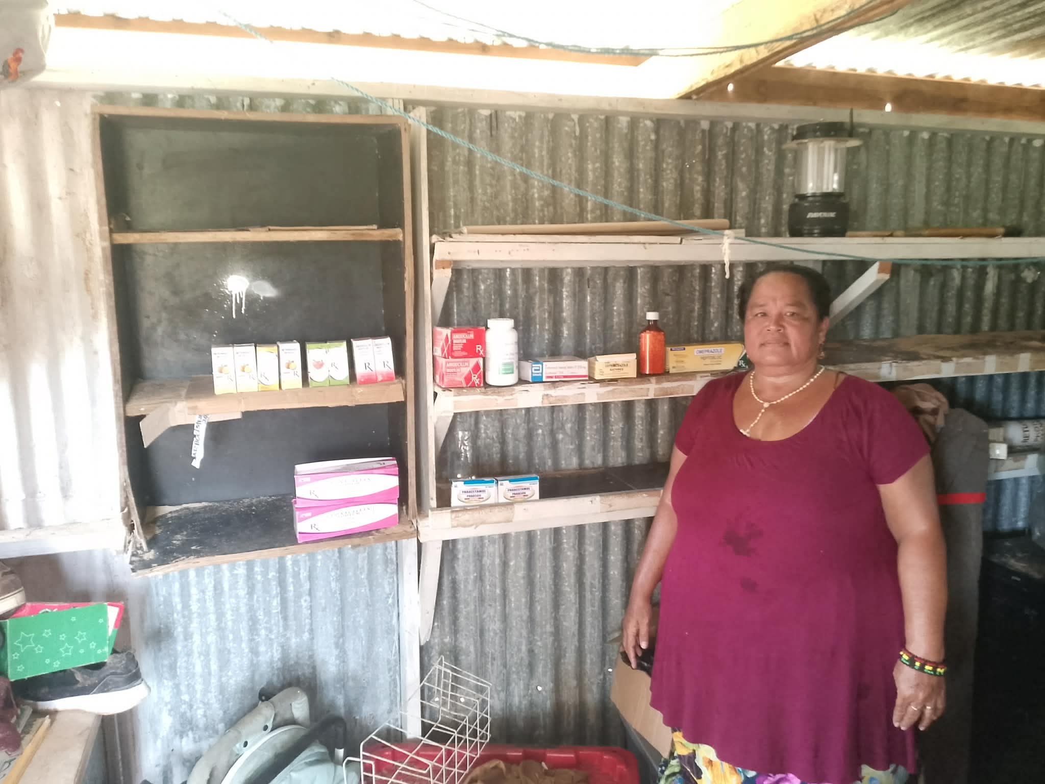 Health worker stand in front of a partially destroyed health dispensary in Chuuk Lagoon