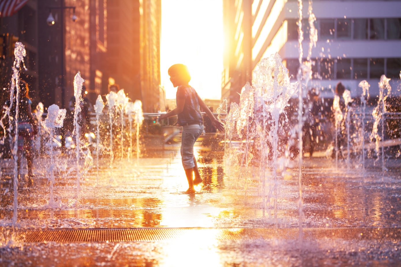 resource-directory child playing in water fountains in a city
