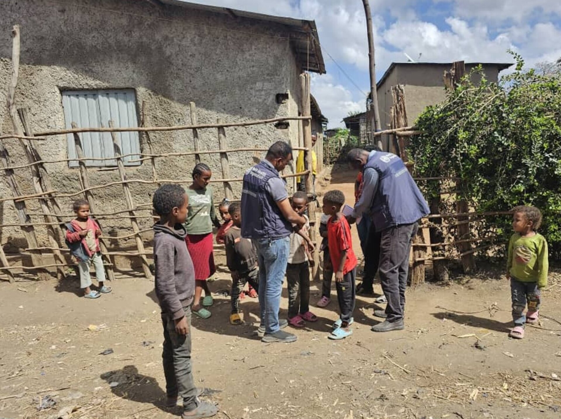 2 W.H.O staff speaking with children in village