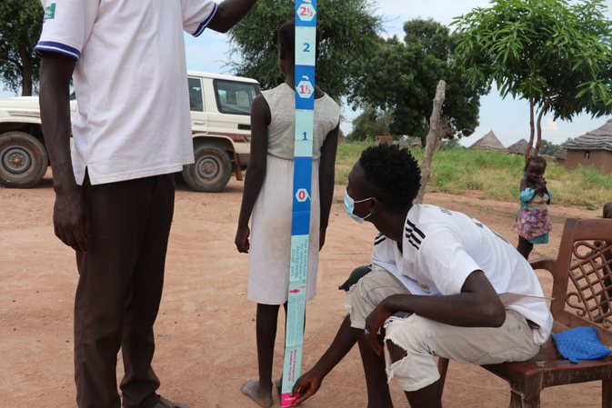 Measuring the height of young girl to determine her eligibility to receive the bilharzia treatment. South Sudan