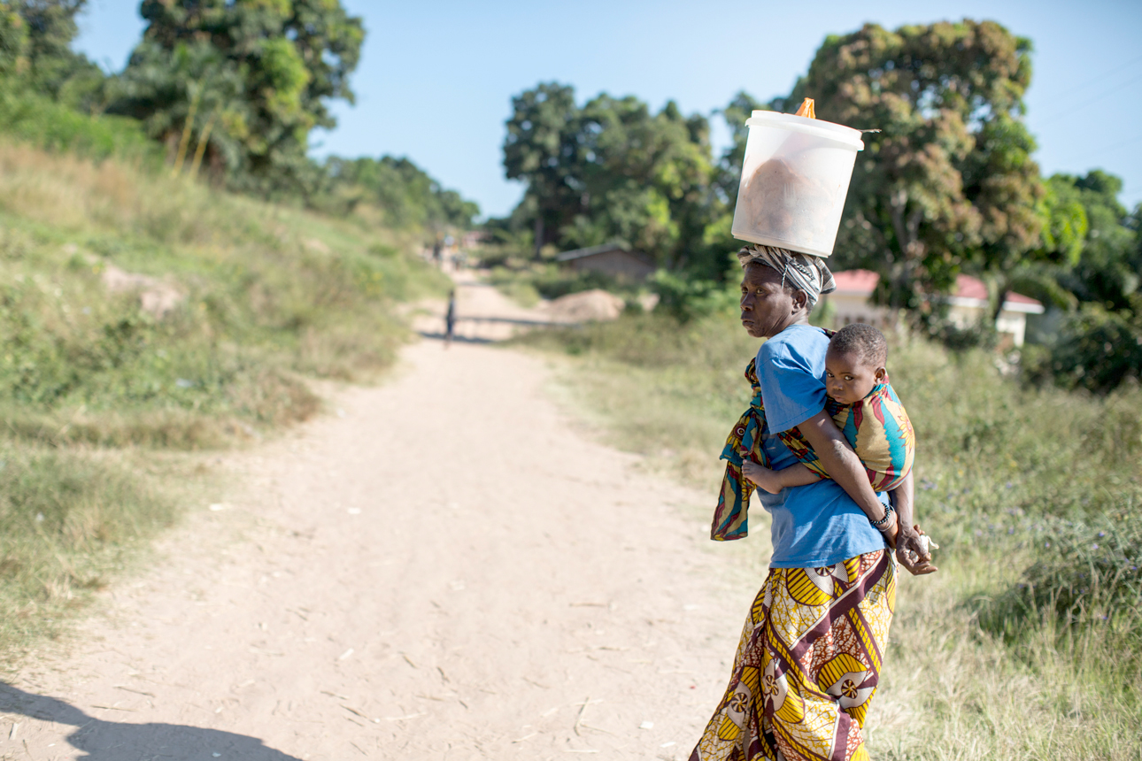 Woman with baby walking on a road in the Democratic Republic of the Congo