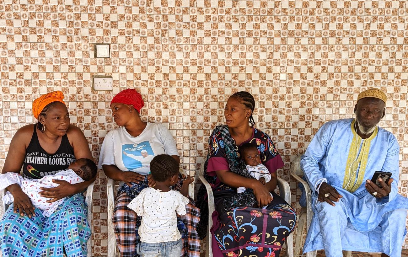 3 women, 3 babies and 1 man are sitting on chairs