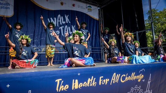 A group of children and adolescents performing on a stage.