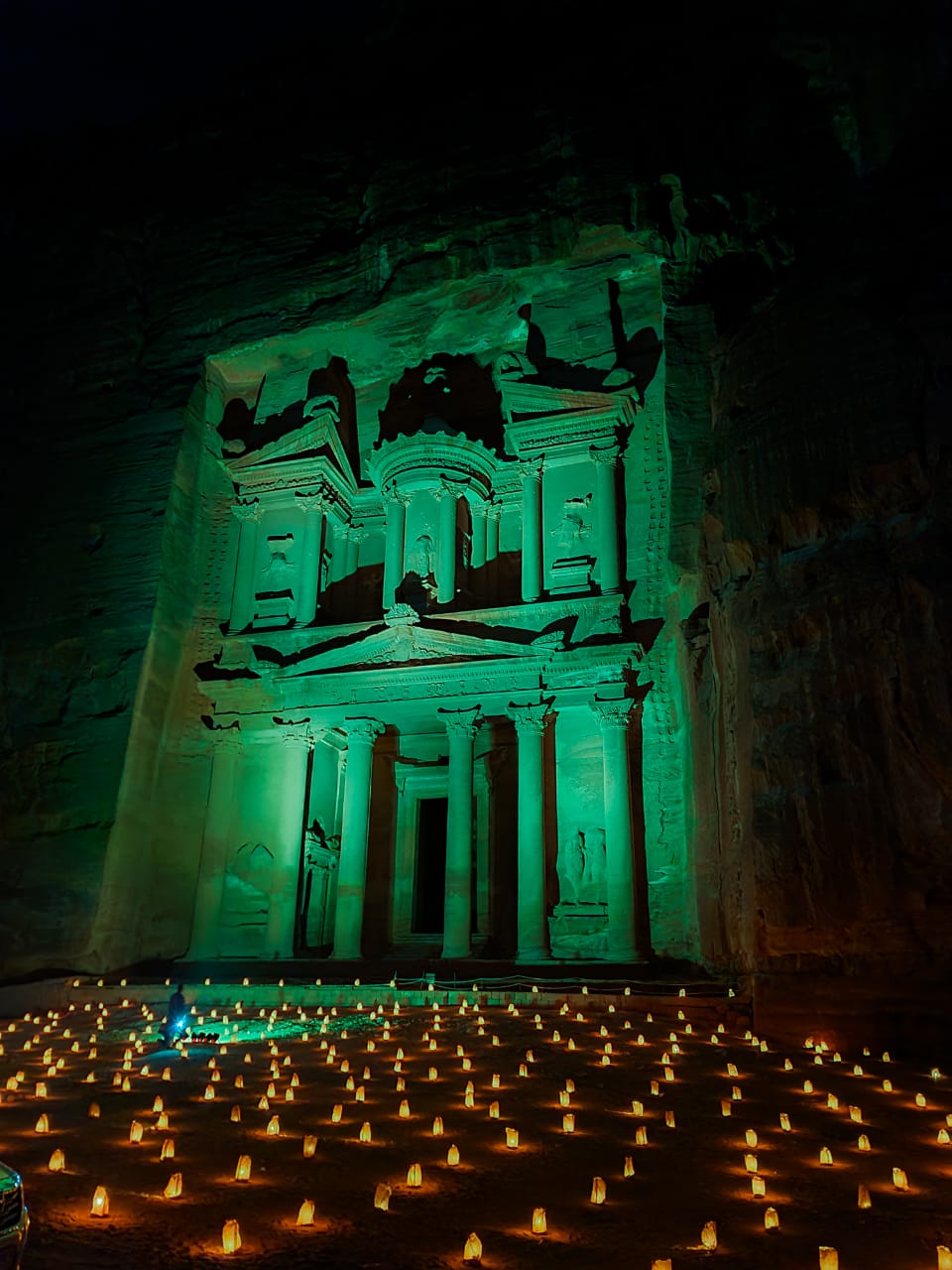 EMR- Petra Monument, Petra, Jordan Petra’s Treasury lit in green with lanterns in front at night.
