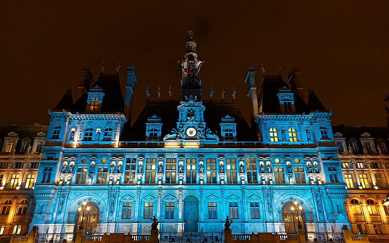 EUR- City Hall, Paris, France Historic Paris City Hall lit in blue at night with a central clock tower.