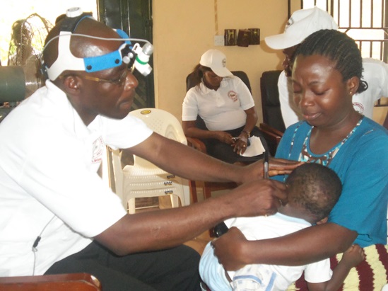 A baby is being examined by a health professional