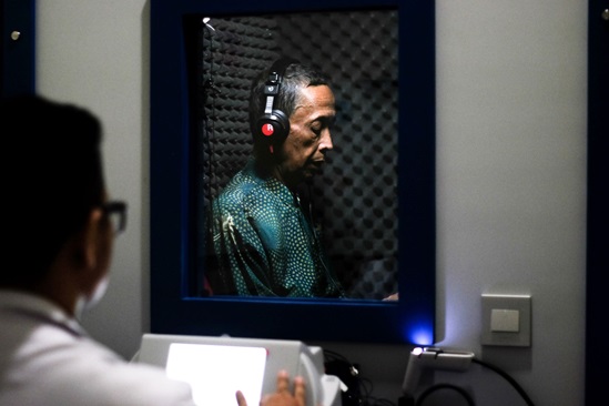A man is using headphones to test his audition