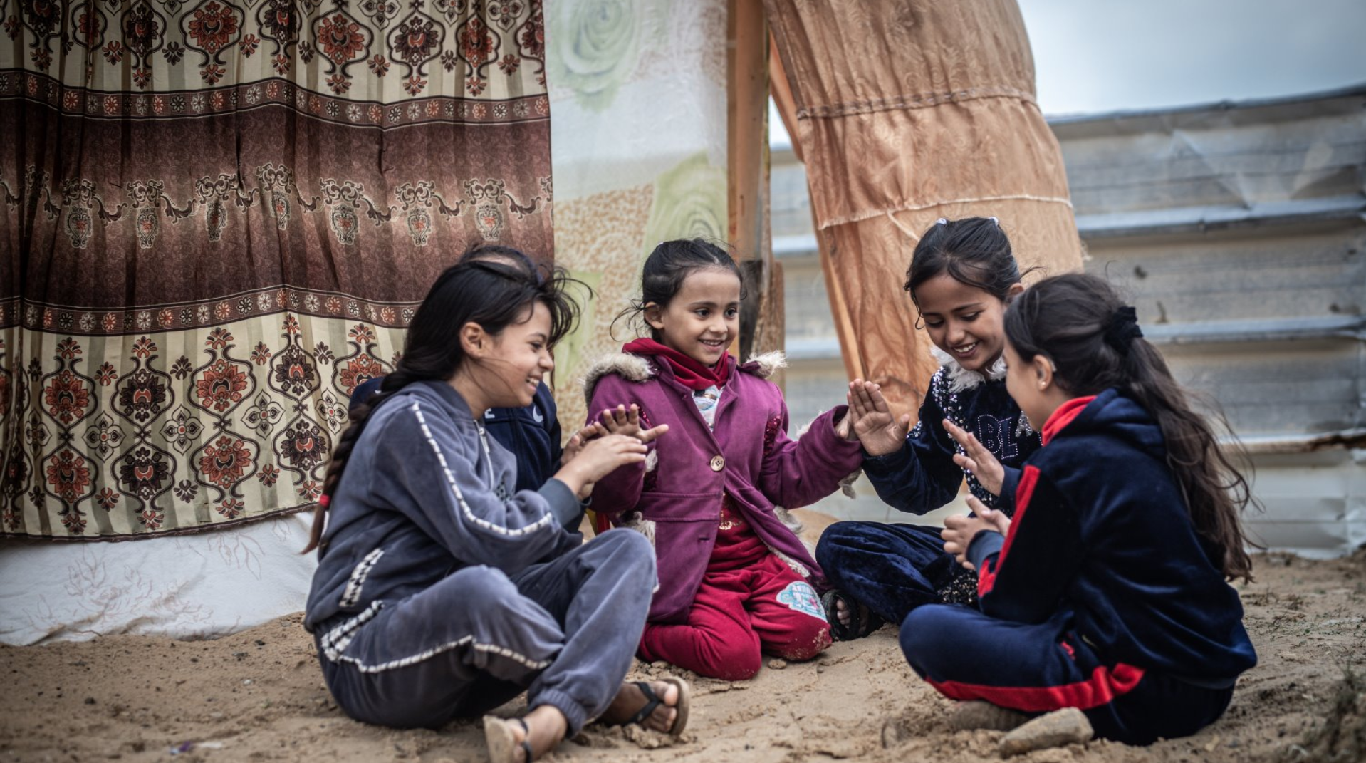 Girls sitting in a circle playing