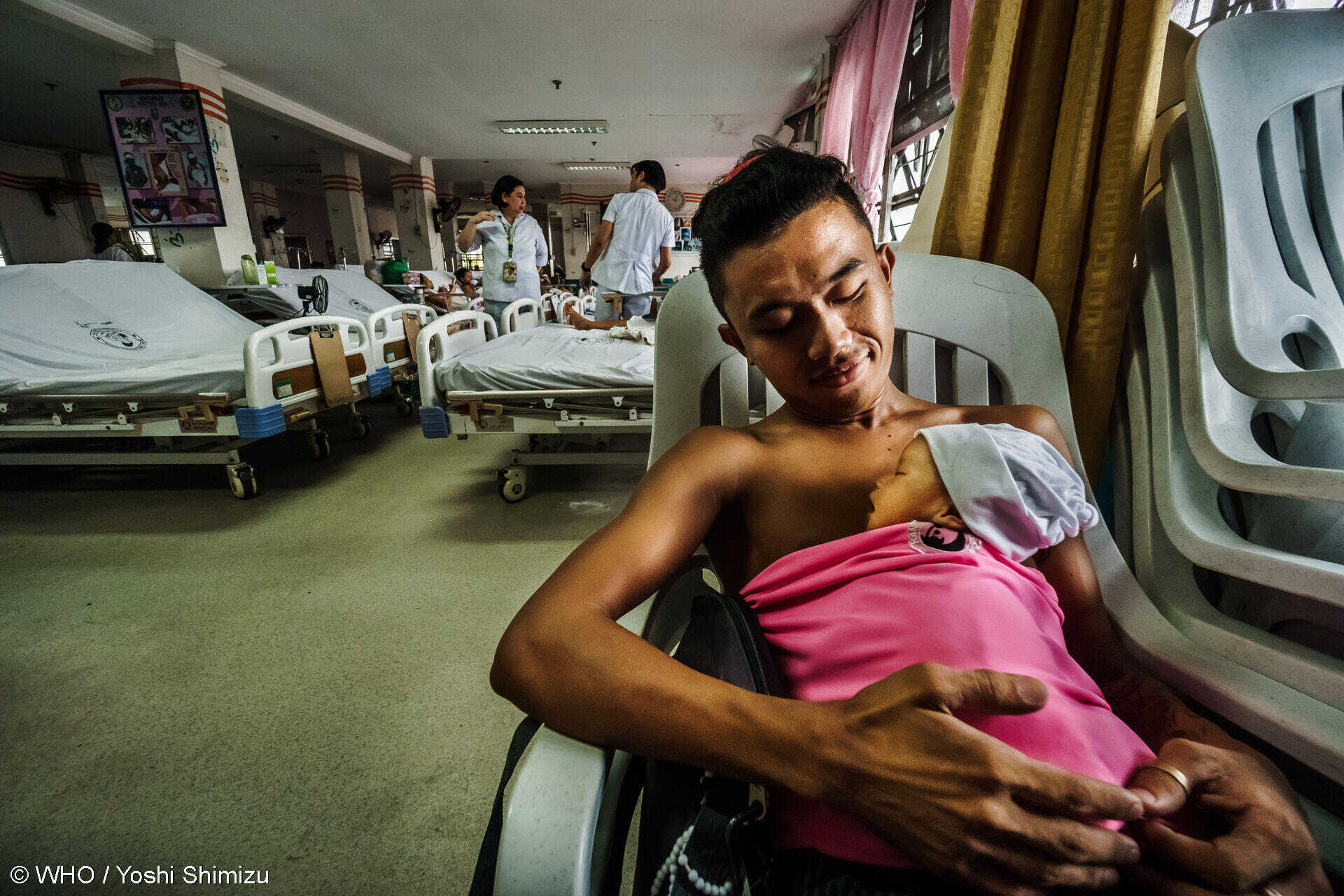 Father practices skin to skin contact with his lbw newborn baby Father practices skin-to-skin contact with his low birth weight newborn baby at the Kangaroo Mother Care (KMC) ward.