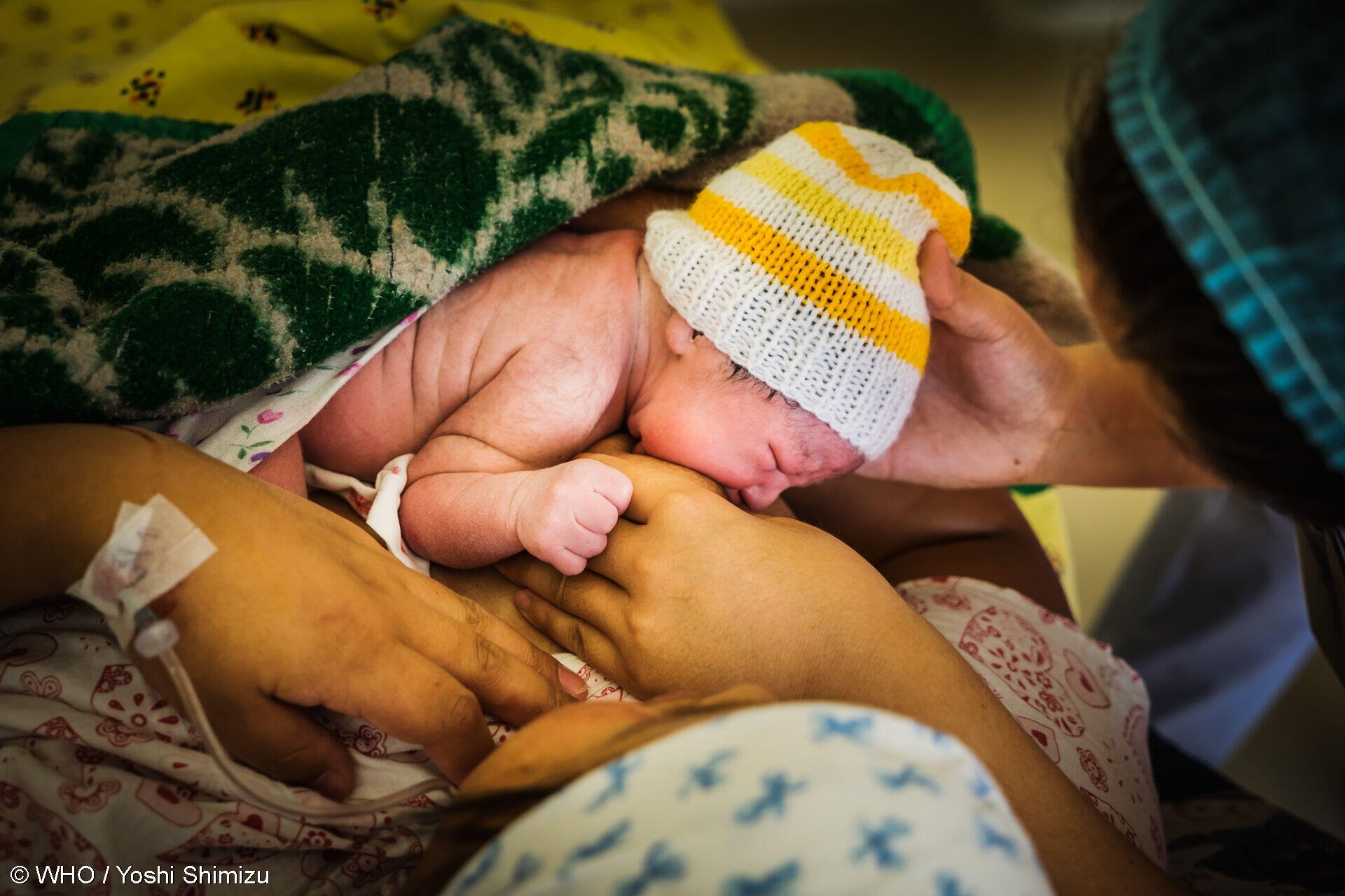 Mother and her newborn baby in skin-to-skin contact and breastfeeding immediately after birth.