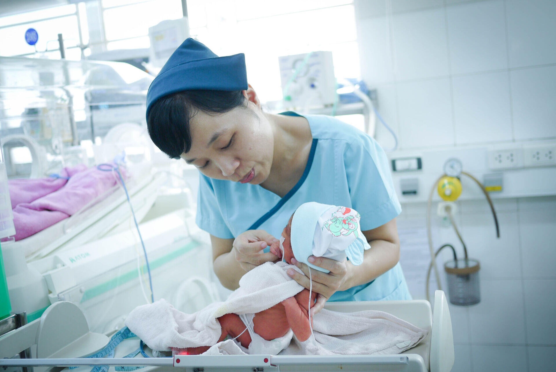 Nurse weighing a baby in the neonatal care unit room