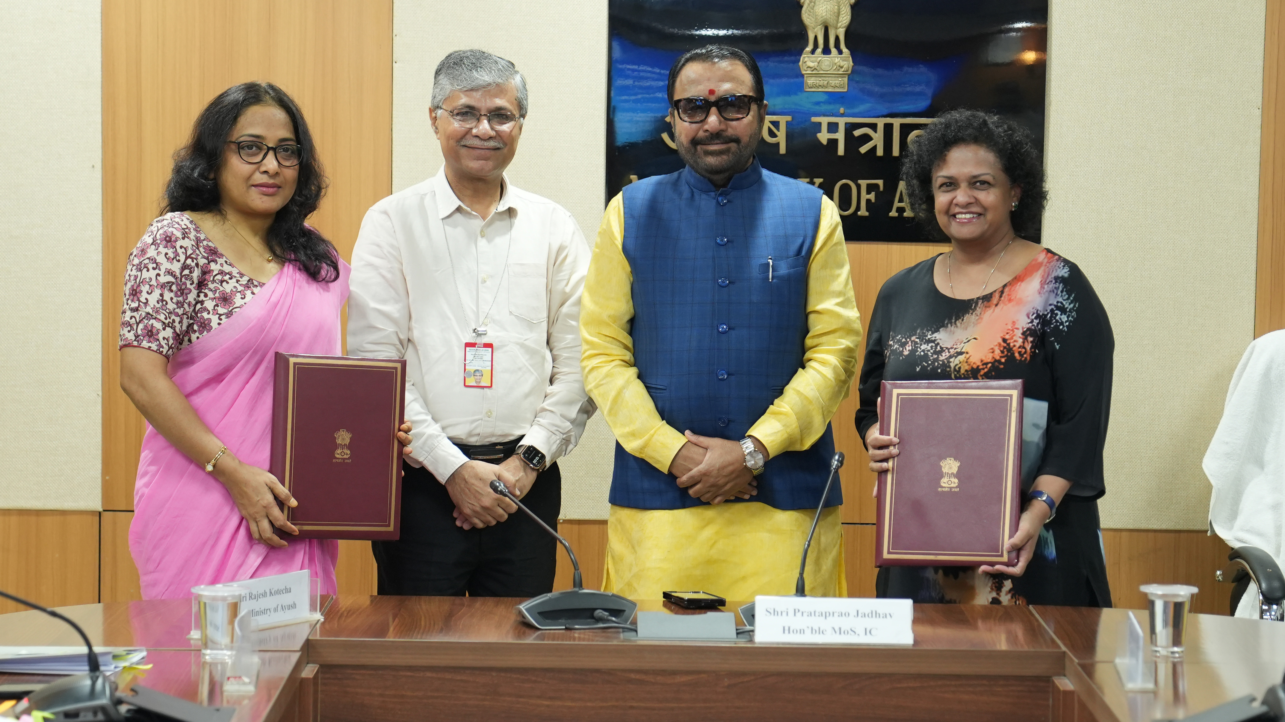 Four people holding memorandum of understanding documents