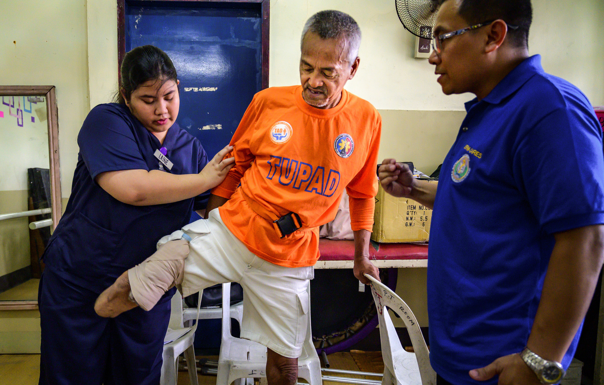 Two health workers assisting a patient.