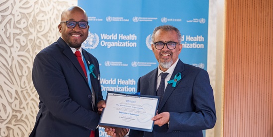 A man hands over a certificate to another man, both standing