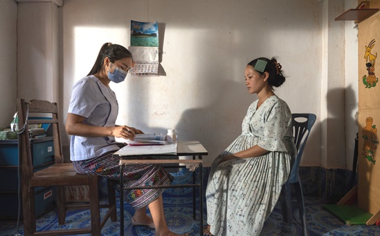 Health worker attending a pregnant women in a clinic's room