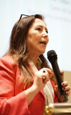Woman standing and speaking into a microphone