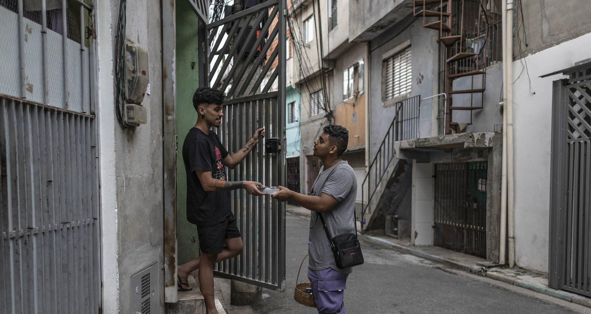 An individual delivers a good to a person standing at the door