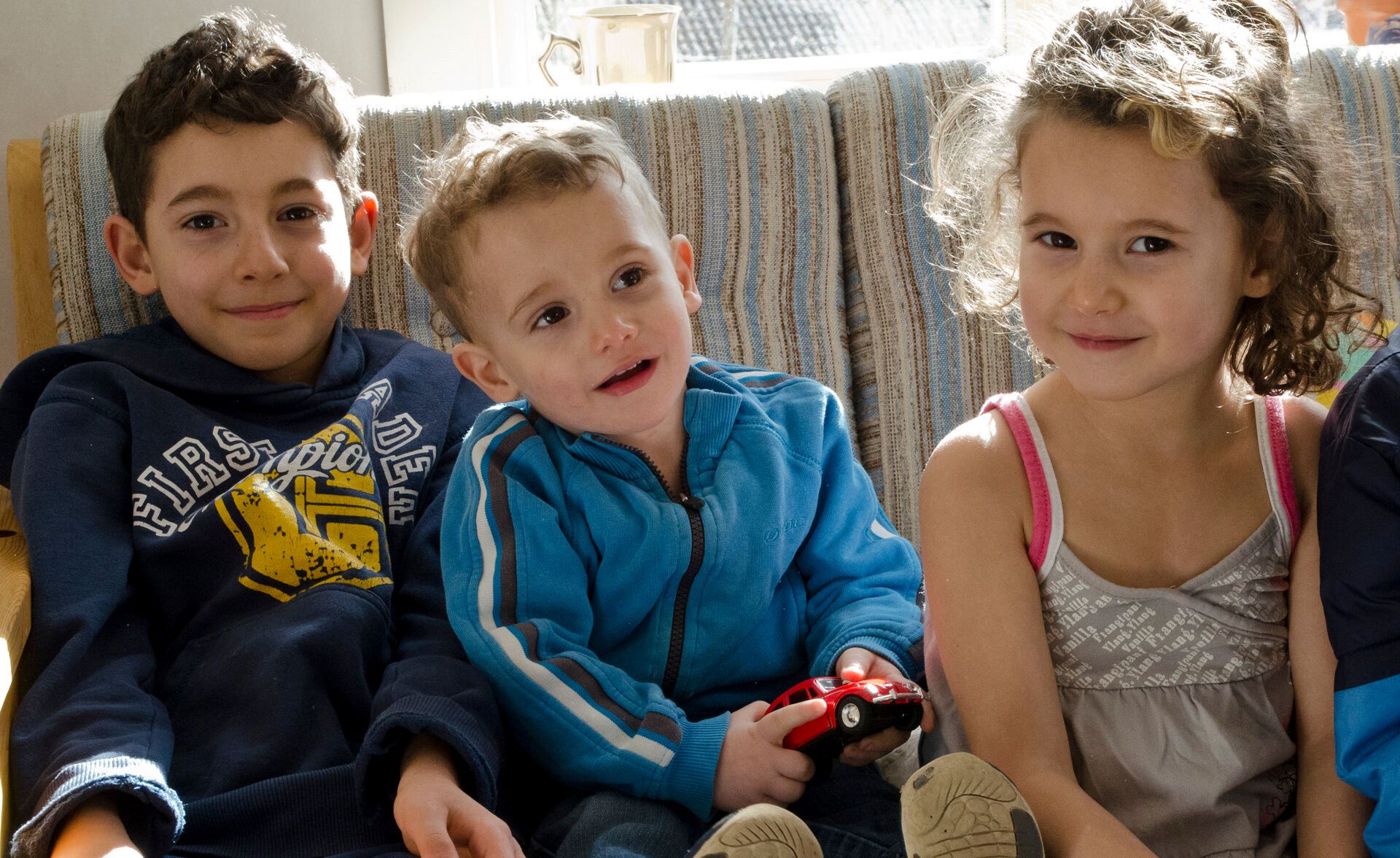 Children sitting on a sofa and smiling