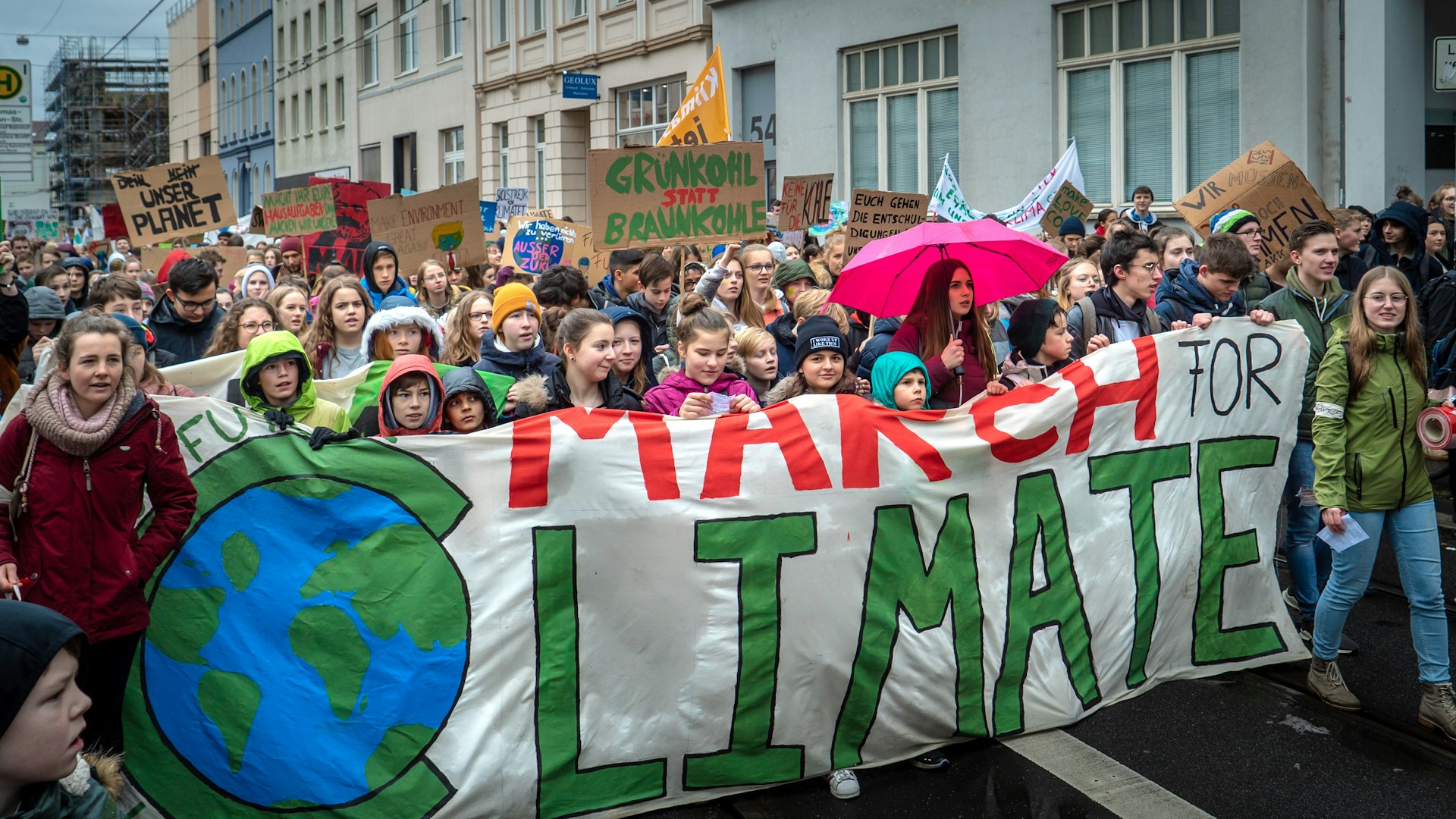 People marching in the street with a banner March for Climate