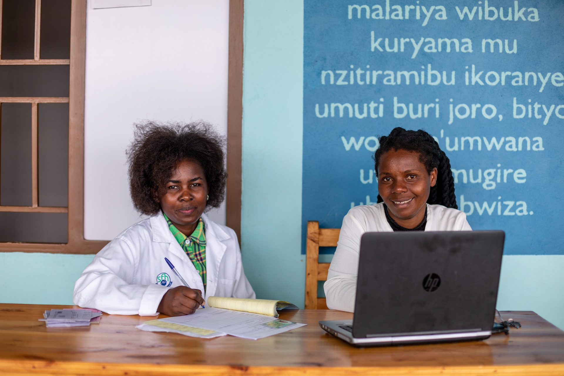 Josiane, left, is a laboratory technician at Mishungero Health Post in Nyaruguru District, Rwanda. She sits next to Claudine, right, the receptionist at Mishungero Health Post