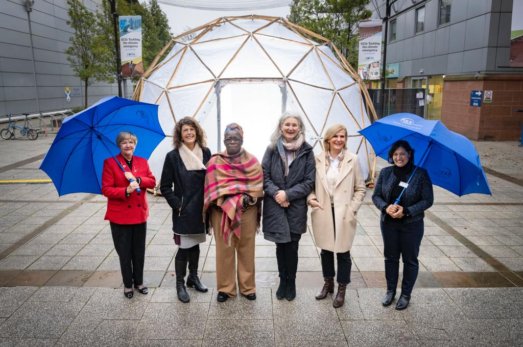 The organisers and key-note speakers of the 2021 global conference on climate change and health at the Glasgow Caledonian University, standing in front of the art installation ‘the pollution pod’