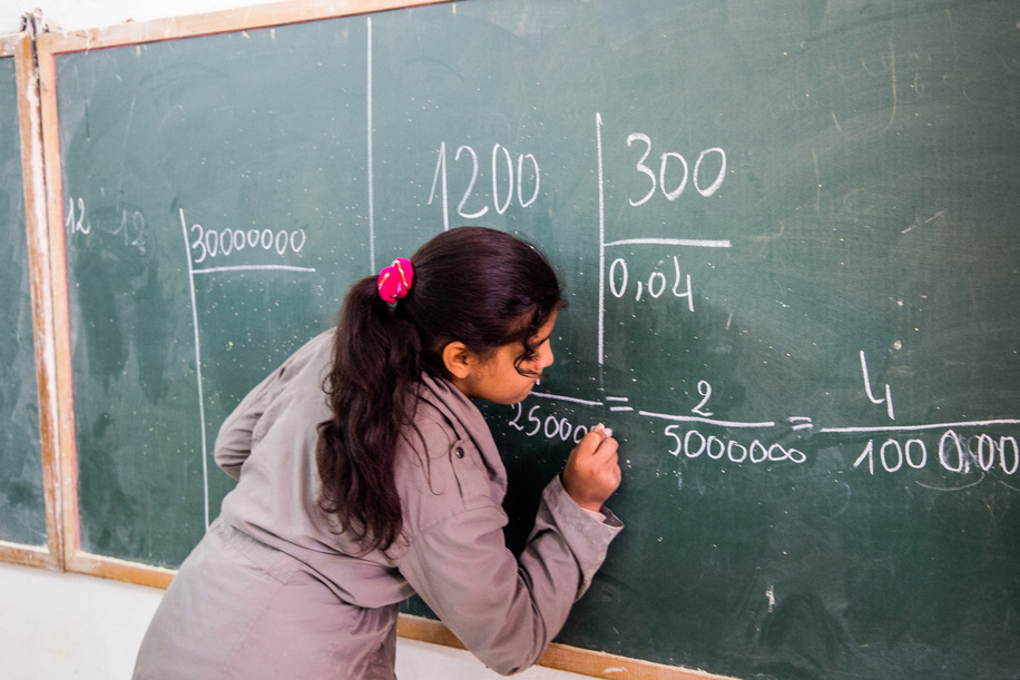 Girl writing maths on board