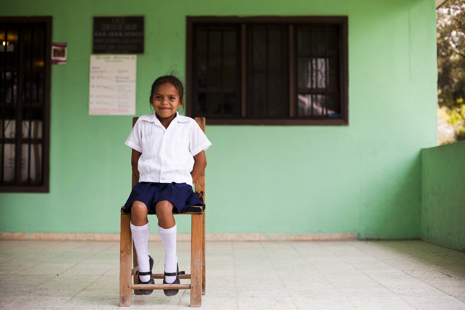 Une jeune enfant assise sur une chaise