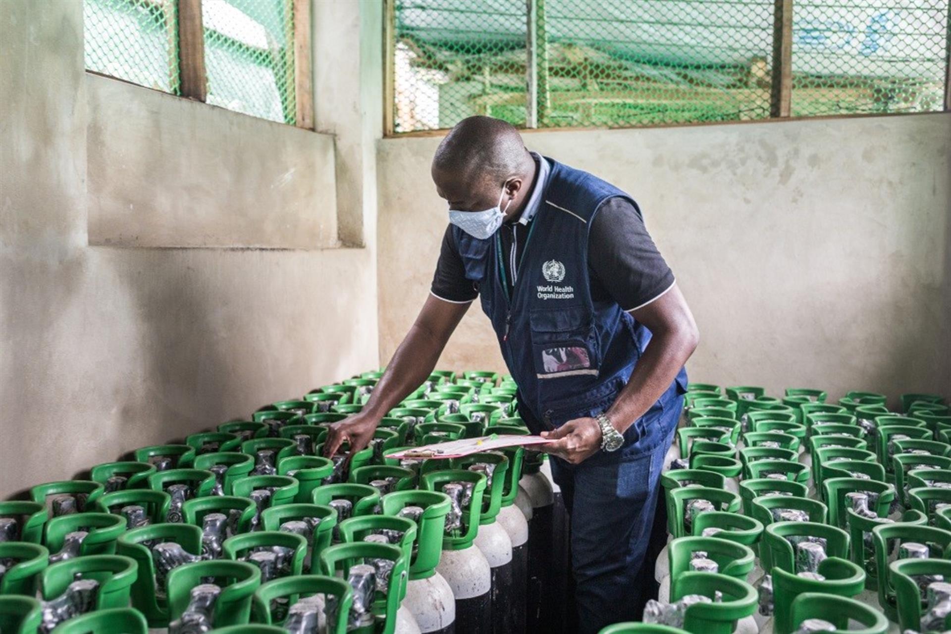 Man stands in a room full of oxygen cylinders