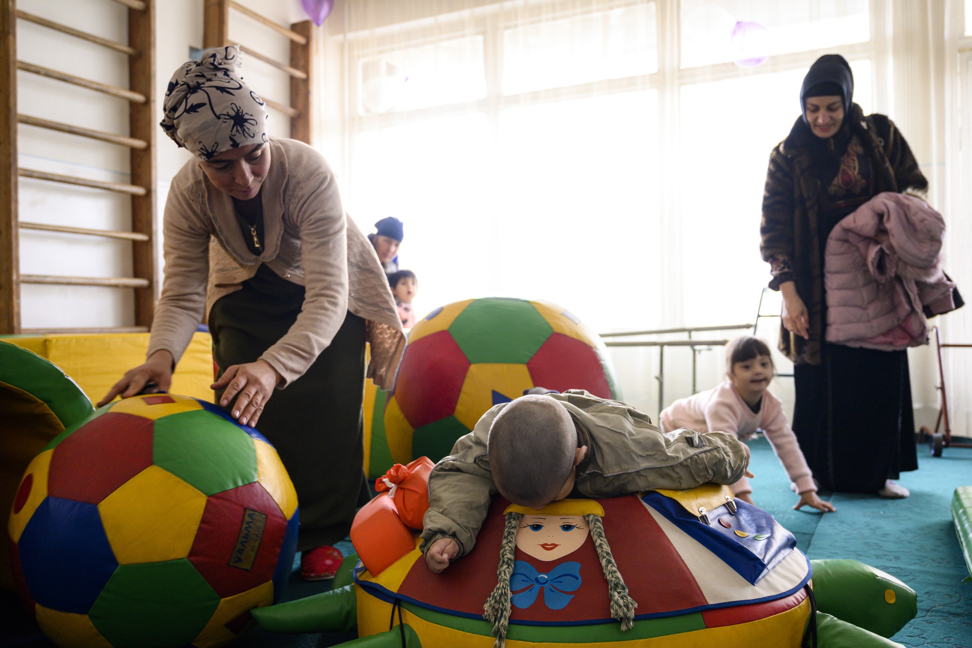 workforce-objectives 3 children receiving rehabilitation accompanied by 2 female health workers and a family member