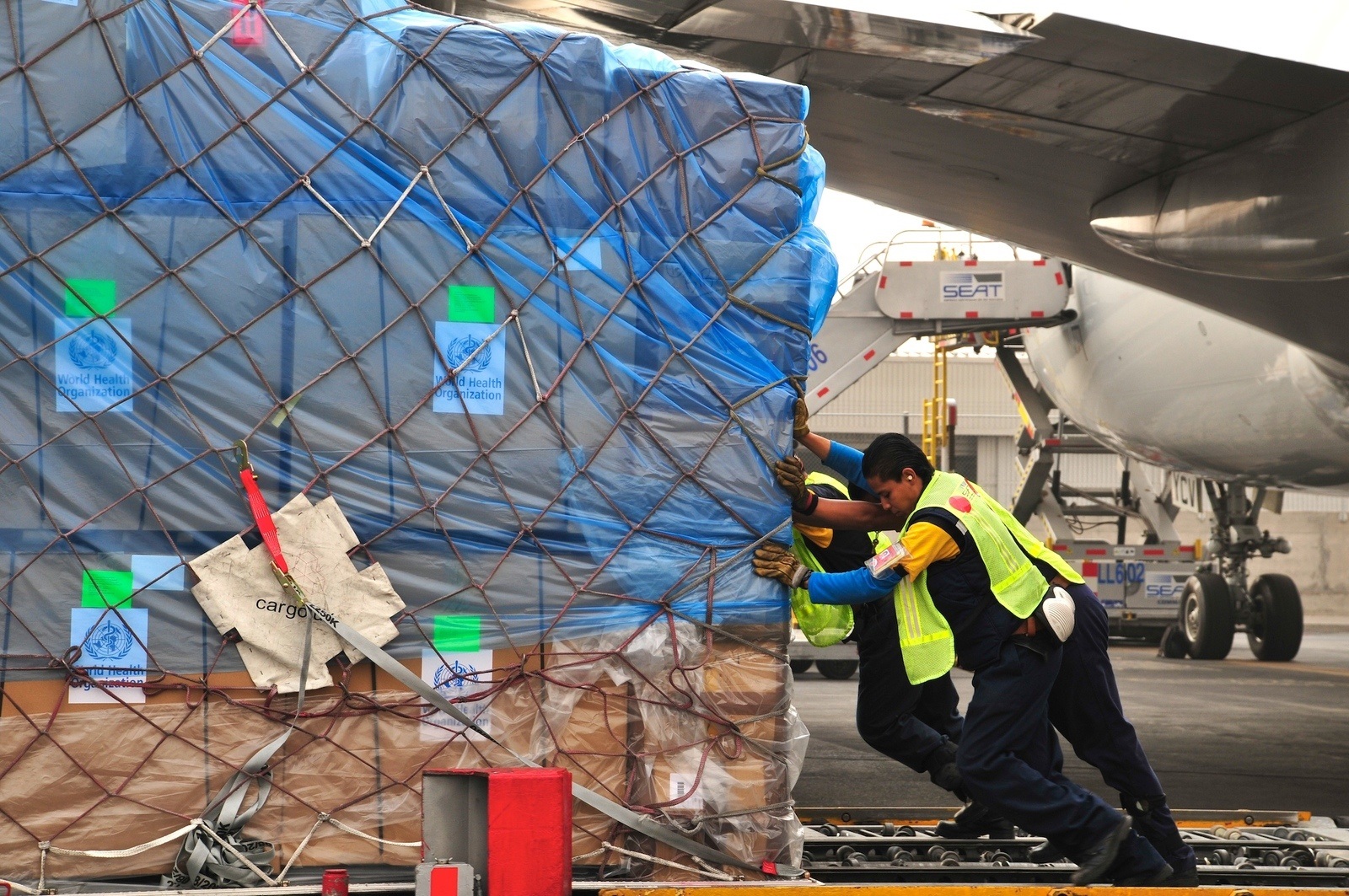 WHO_004810 Unloading of boxes containing Tamiflu (flu treatment and flu prevention) of a plane.