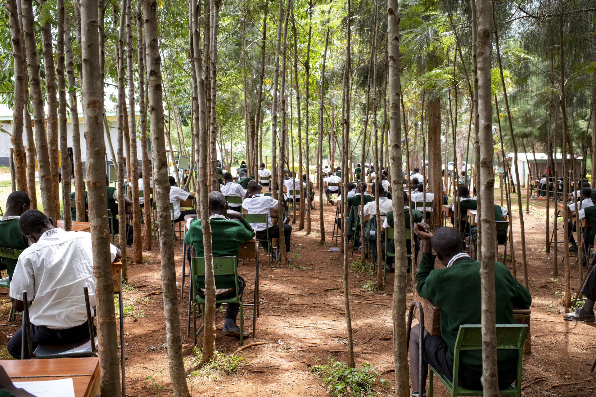 Students sitting at tables for an exam in an open air setting