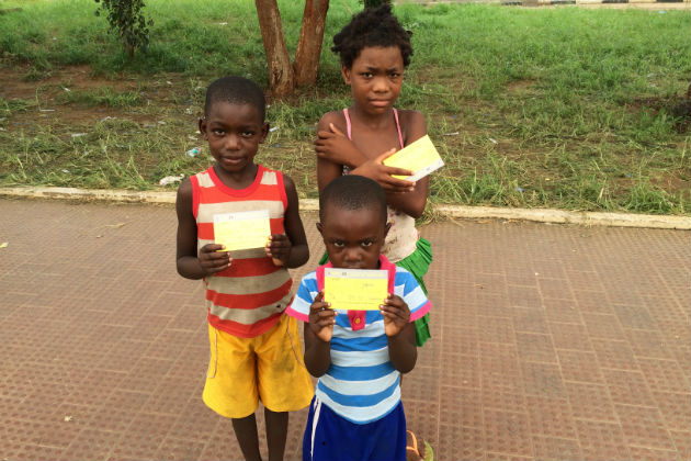 3 children holding yellow fever certificates