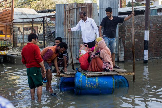 People struggle to keep their belongings dry in the midst of a flood.