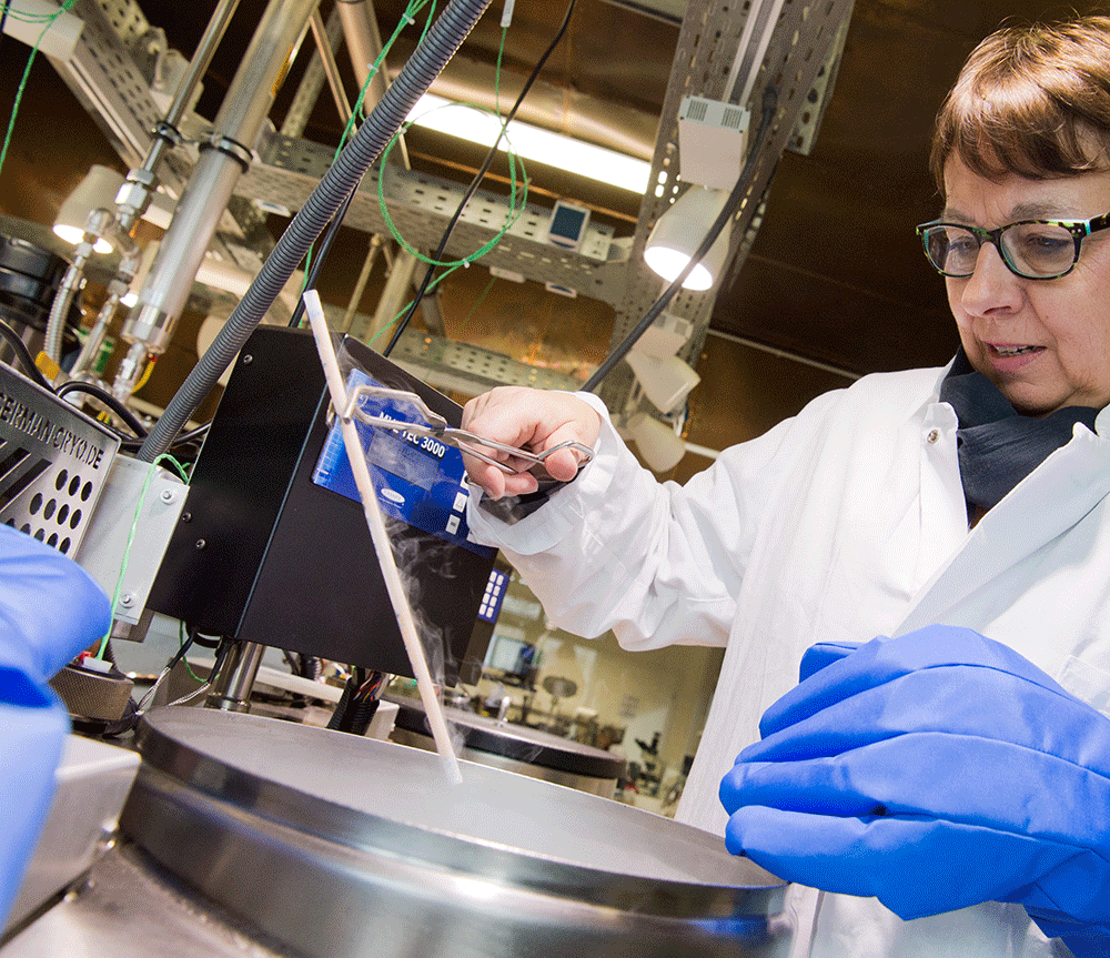 A scientist woman pulling out a tube from a freezer for genetic testing